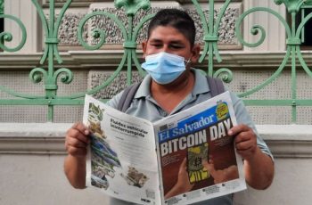 Mies lukee sanomalehteä Bitcoin -tiedoilla El Salvadorissa